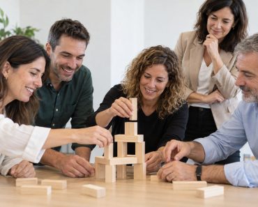 Grupo de compañeros colaborando en una construcción con piezas de madera durante una actividad
